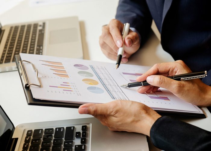 Business concept. Business people discussing the charts and graphs showing the results of their successful teamwork. Selective focus.